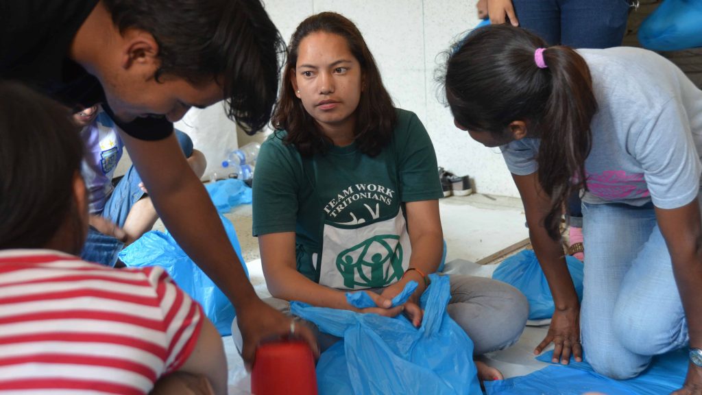 Volunteers help to put together food packs for earthquake victims in Nepal.