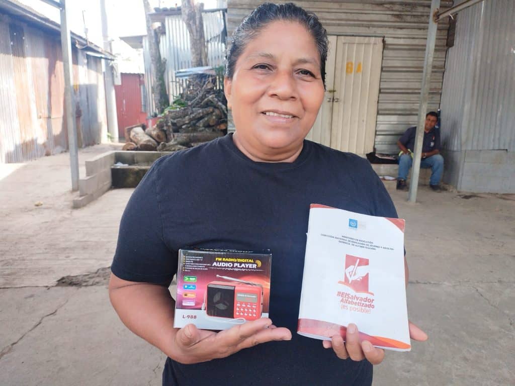 A woman from El Salvador holds her literacy certificate. 