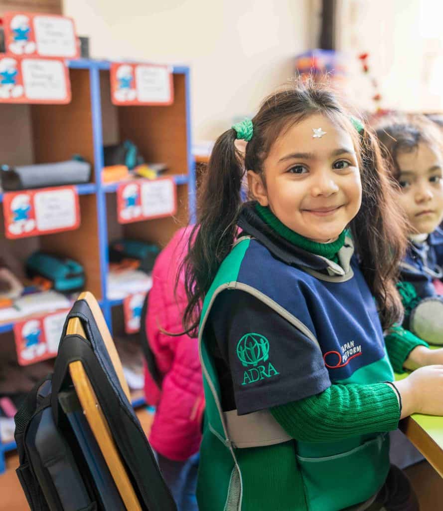 ADRA International logo on children's clothing at a community event or educational setting.