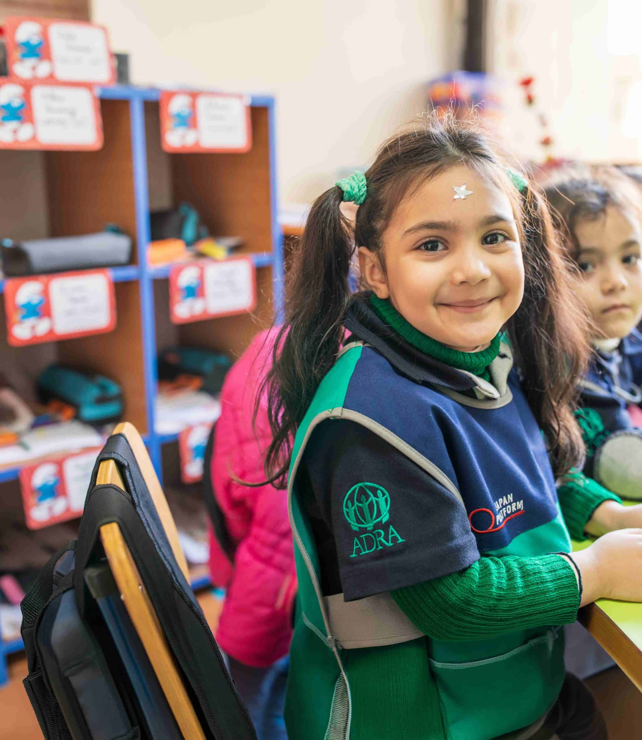 ADRA International logo on children's clothing at a community event or educational setting.