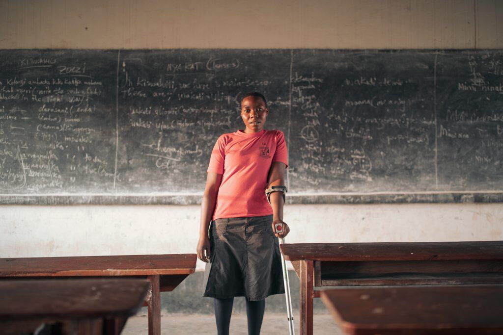 Accessible, inspiring student in classroom with blackboard, highlighting education barriers and resi.