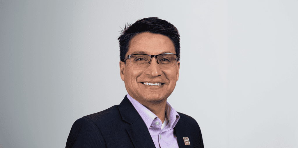 Empowered man smiling in professional attire, representing ADRA International's humanitarian efforts.