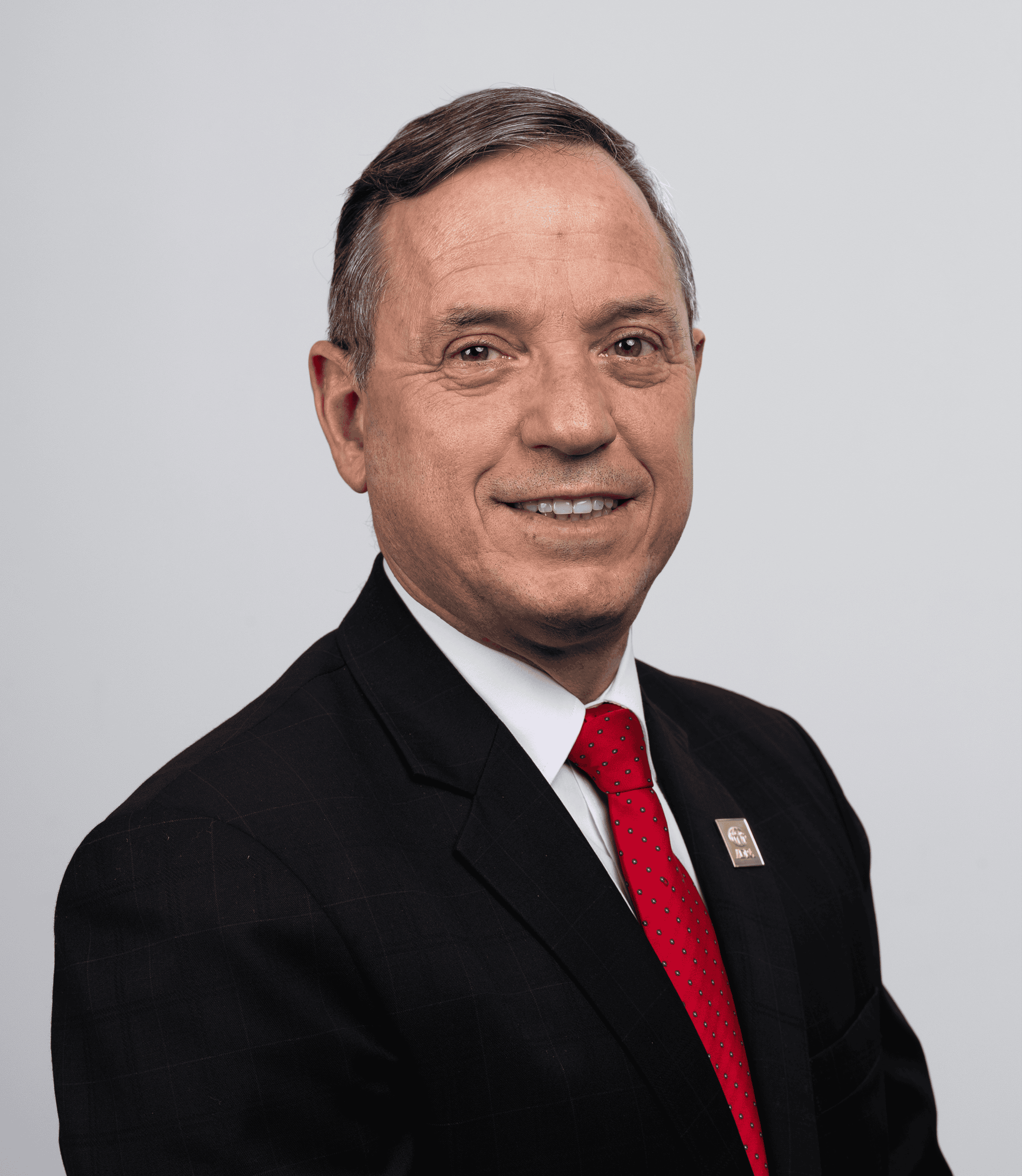 ADRA International leadership team member in formal suit and red tie.