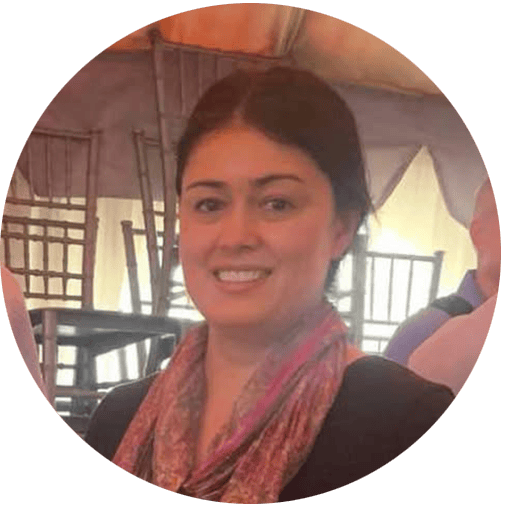 Accessible image of a smiling woman at an ADRA International event, indoors with a tent-like structu.