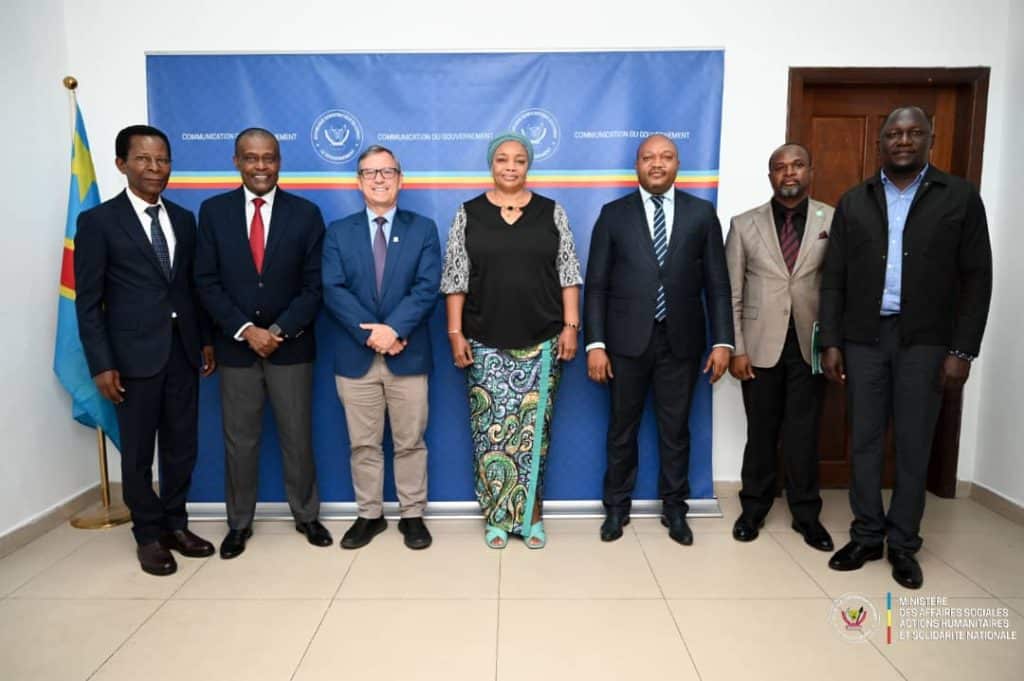 Group of diverse professionals at ADRA International event in front of a blue backdrop.