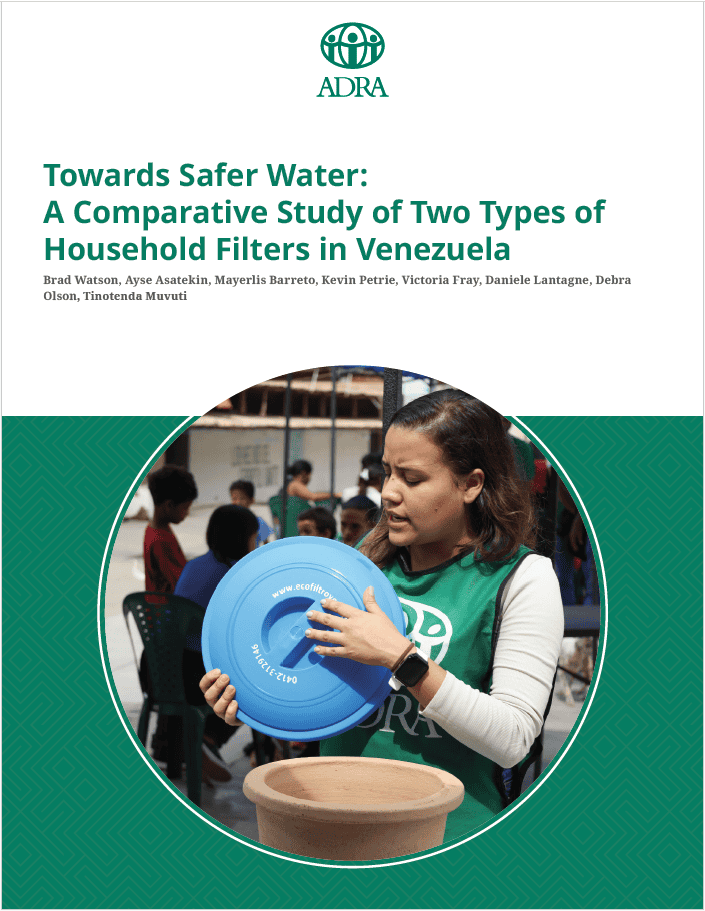 Woman demonstrating household water filter at community event in Venezuela.