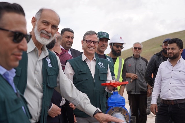 Group of officials and engineers at water infrastructure project site.